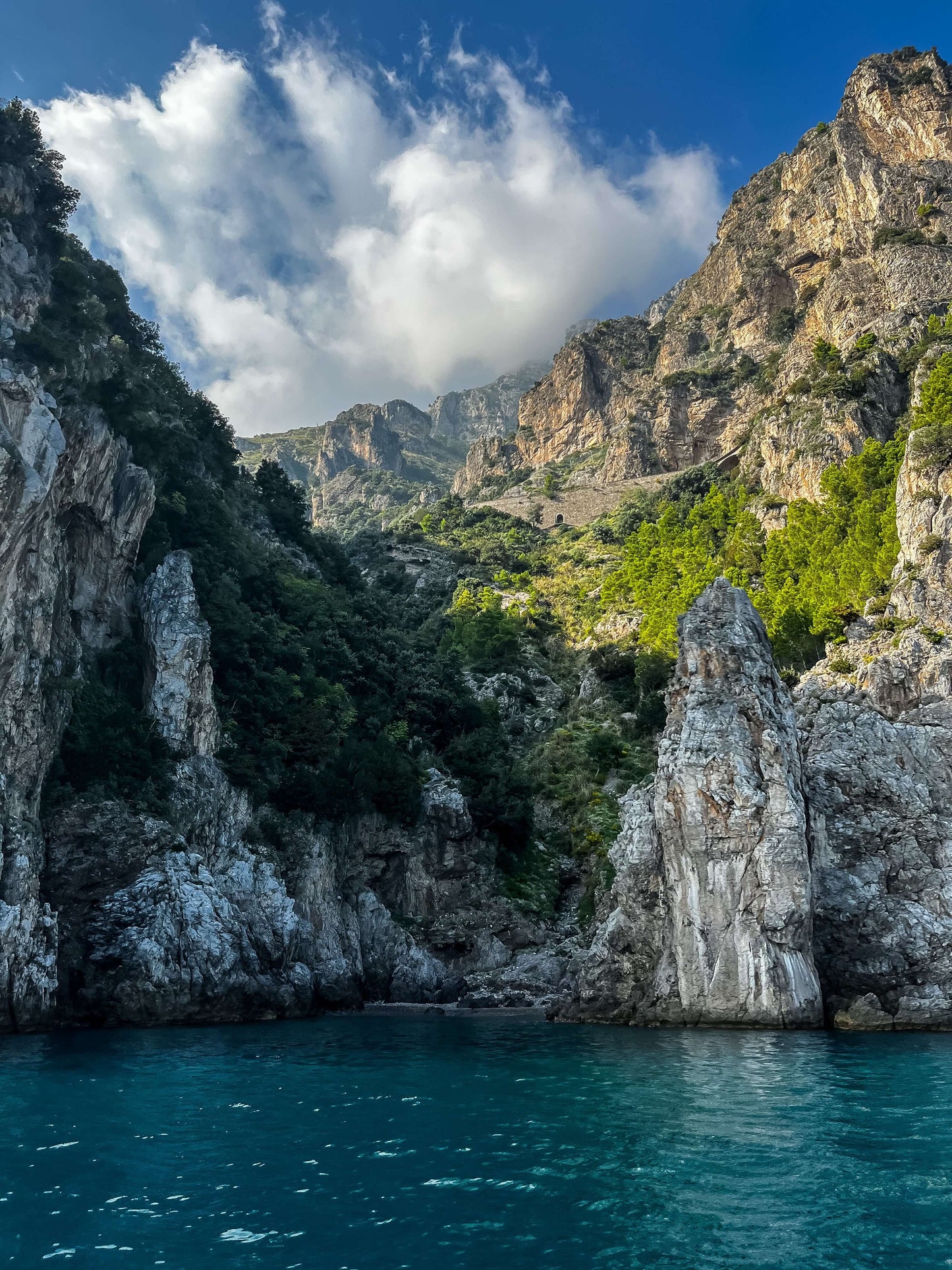 Daytime view of the stunning Amalfi Coast cliffs and crystal blue water, perfect for adding luxury and sophistication to any room.